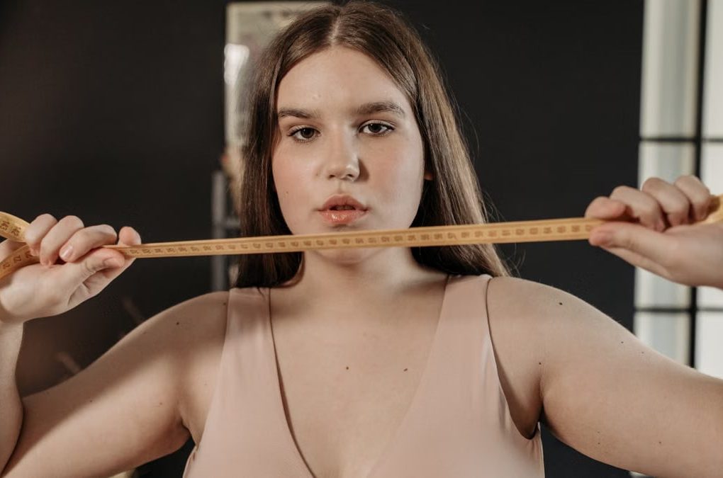 Portrait of a confident woman holding a tape measure, symbolizing self-care and body positivity.